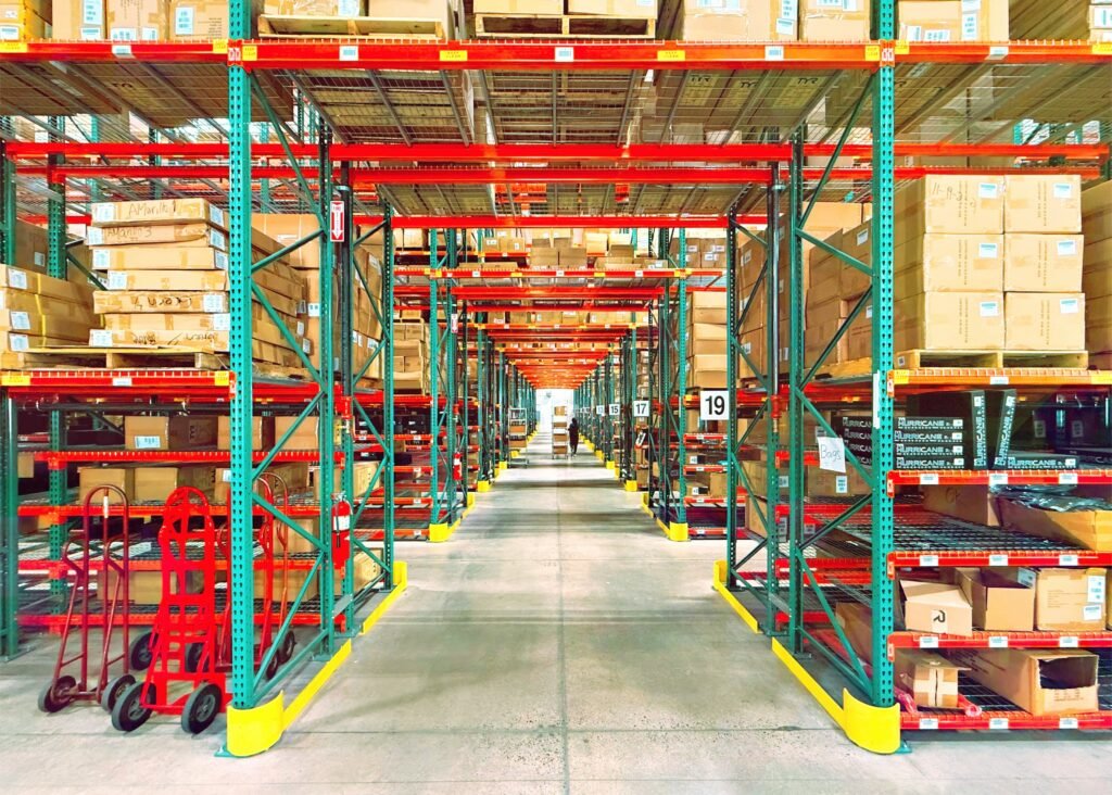 Warehouse interior featuring organized pallet racking systems with stacked boxes, highlighting efficient storage solutions relevant to warehouse permit compliance and design consultation.